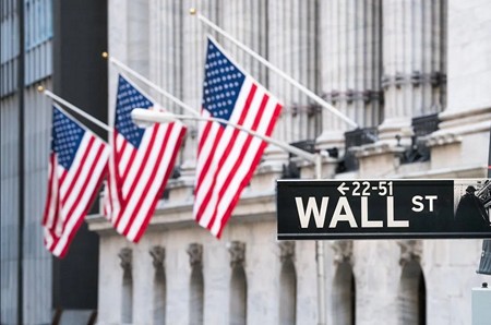 Amerikai zászlók és a Wall Street utca névtábla New Yorkban